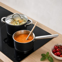 Cookinglife schwarzer Kochtopf mit Gemüsesuppe und schwarzer Stieltopf mit Tomatensuppe auf Induktion