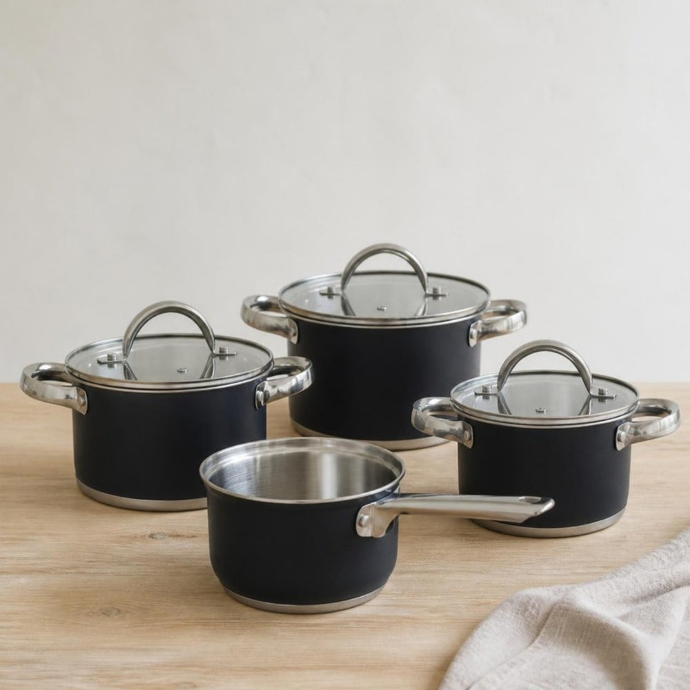 Cookinglife Topfset Schwarz 4-teilig: drei schwarze Kochtöpfe und ein Stieltopf auf einer Eichen-Arbeitsplatte
